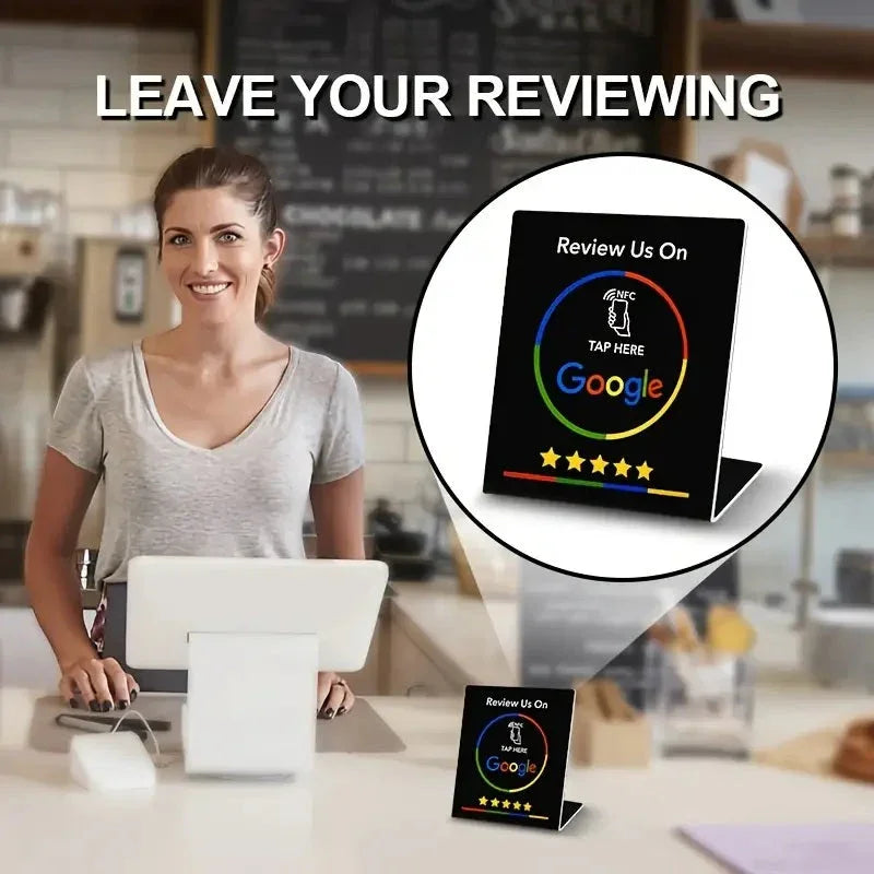 Smiling woman behind counter in cafe with Google review NFC tap sign encouraging customer feedback