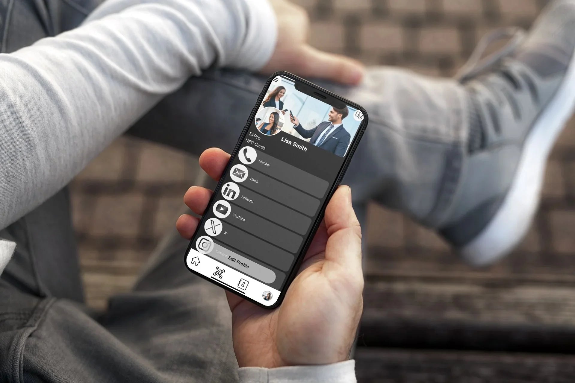 Hand holding iPhone 11 Pro showing digital business card app with social media icons