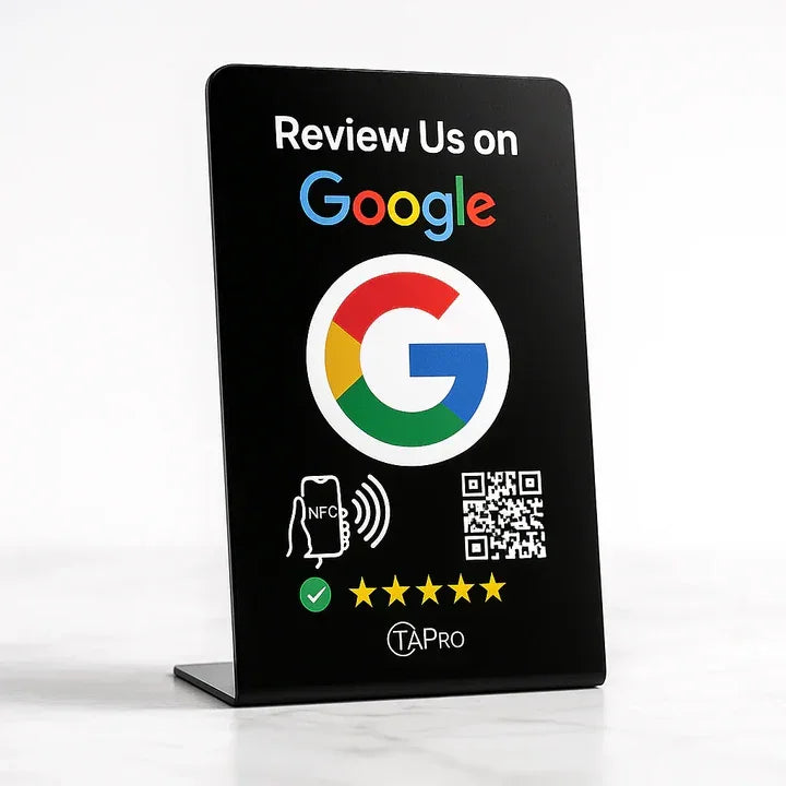 Black Google review sign with QR code, NFC phone icon, and five-star rating on white surface