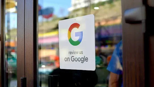 Google review sticker on glass door inviting customers to review business on Google