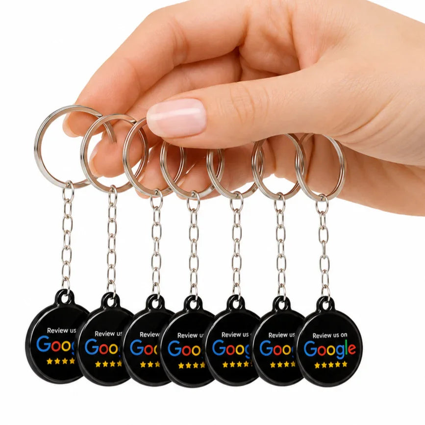 Hand holding black circular NFC keychains with Google review prompt and 5 stars, for contactless customer feedback collection.